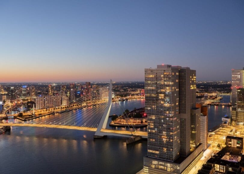 Prachtig uitzicht vanuit het Montevideo gebouw over de verlichte Erasmusbrug en de skyline van Rotterdam bij nacht, met moderne hoogbouw, de Maas, en een sfeervolle stadshorizon op de achtergrond.