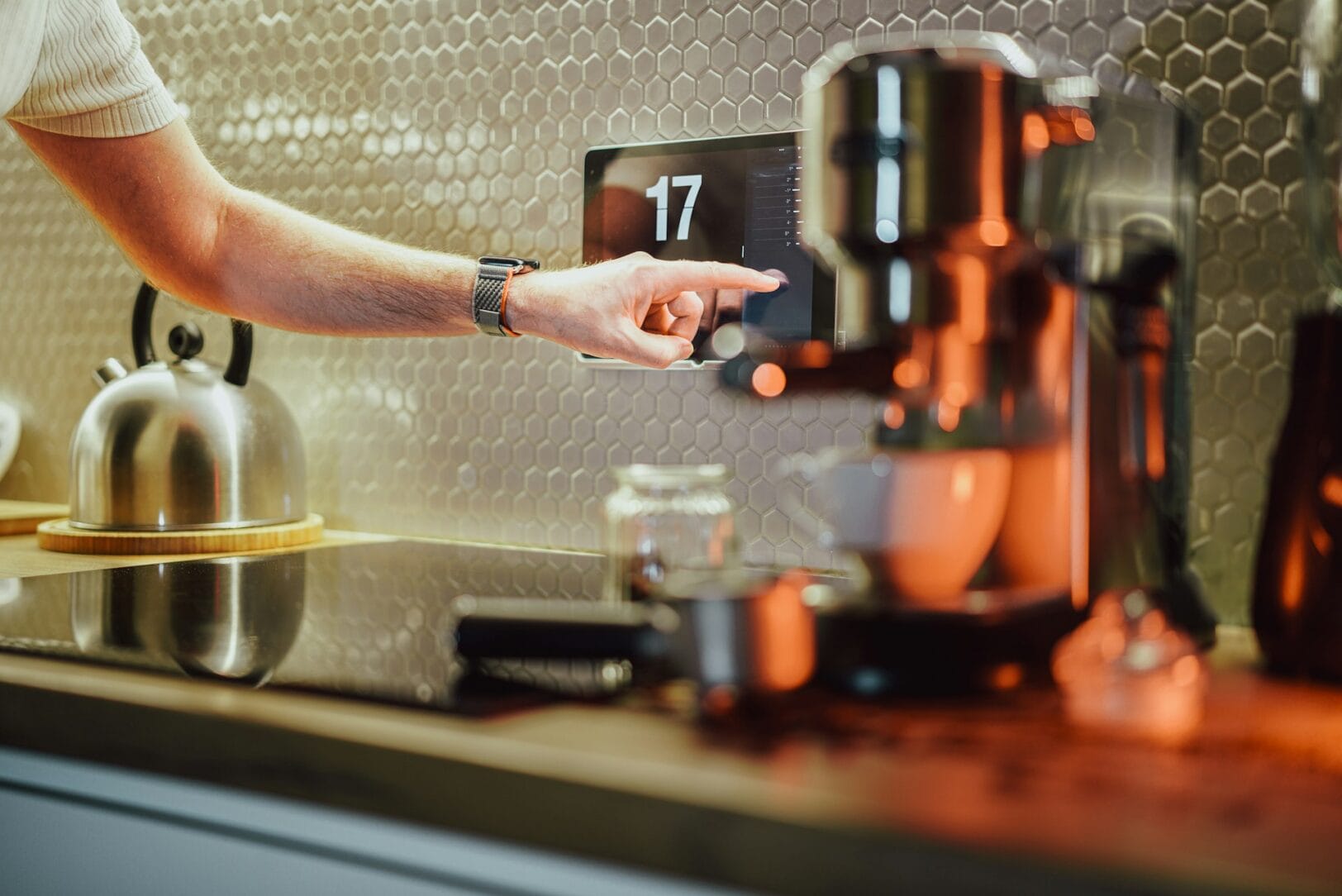 Hand bedient touchscreen in moderne keuken met mechanische ventilatie, voor optimale controle over luchtkwaliteit en klimaatregeling.