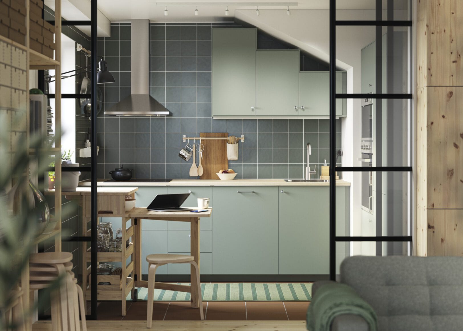 Gezellige IKEA keuken met zwarte fronten, hout en planten in daglicht.