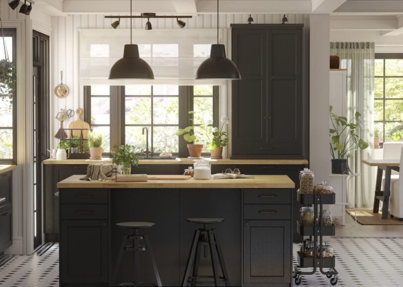 Donkere IKEA-keuken met houten blad, trolley en veel groen bij het raam