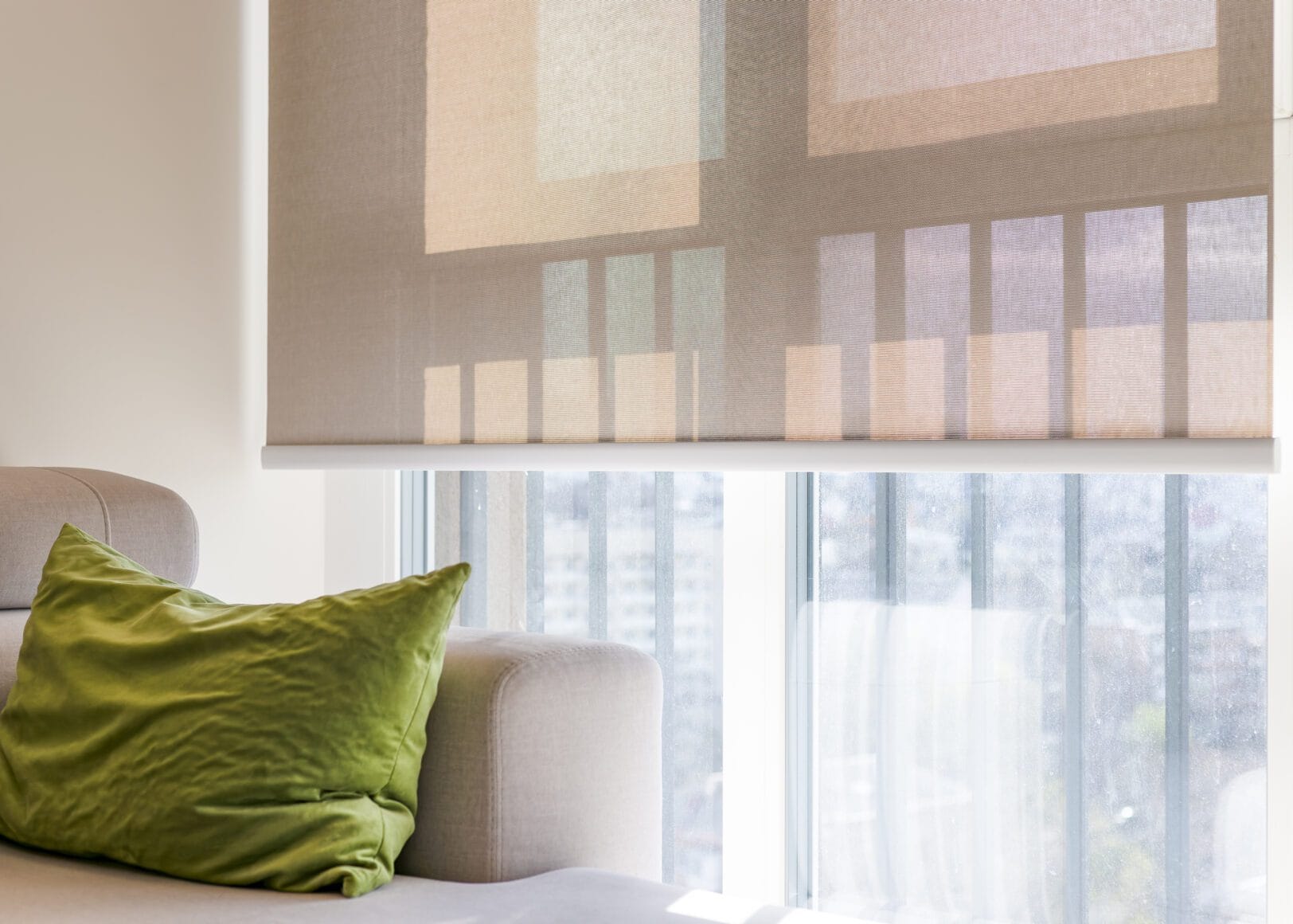 Zacht daglicht dat door lichtdoorlatende rolgordijnen een rustige kamer binnenvalt.